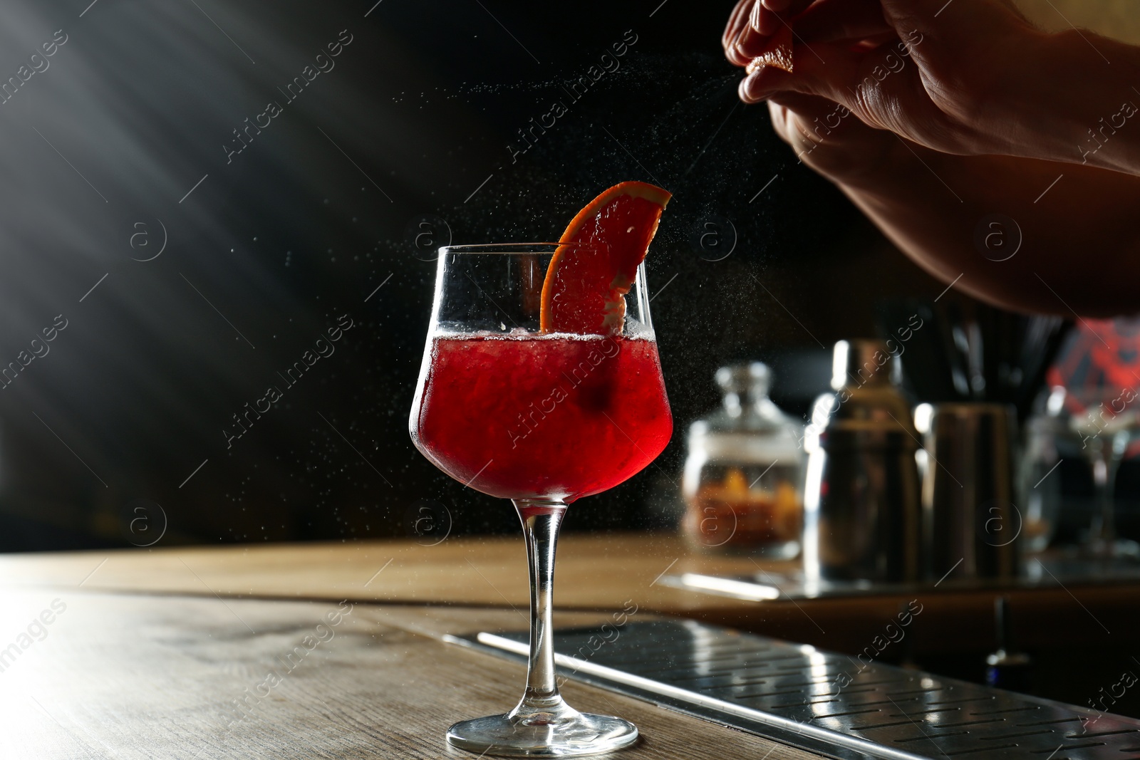 Photo of Bartender preparing fresh alcoholic cocktail at bar counter, closeup