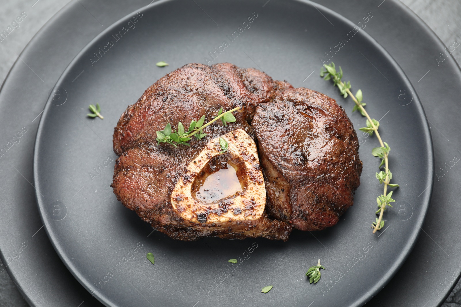 Photo of Delicious roasted beef meat with thyme on plate, closeup