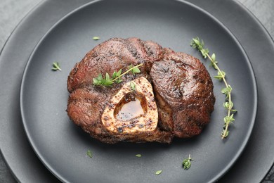 Delicious roasted beef meat with thyme on plate, closeup