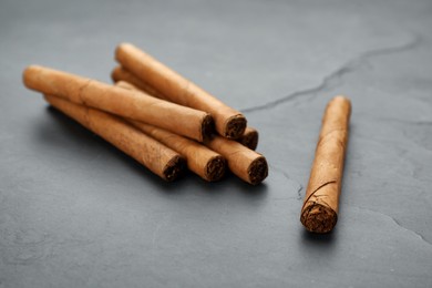 Photo of Cigars wrapped in tobacco leaves on black table