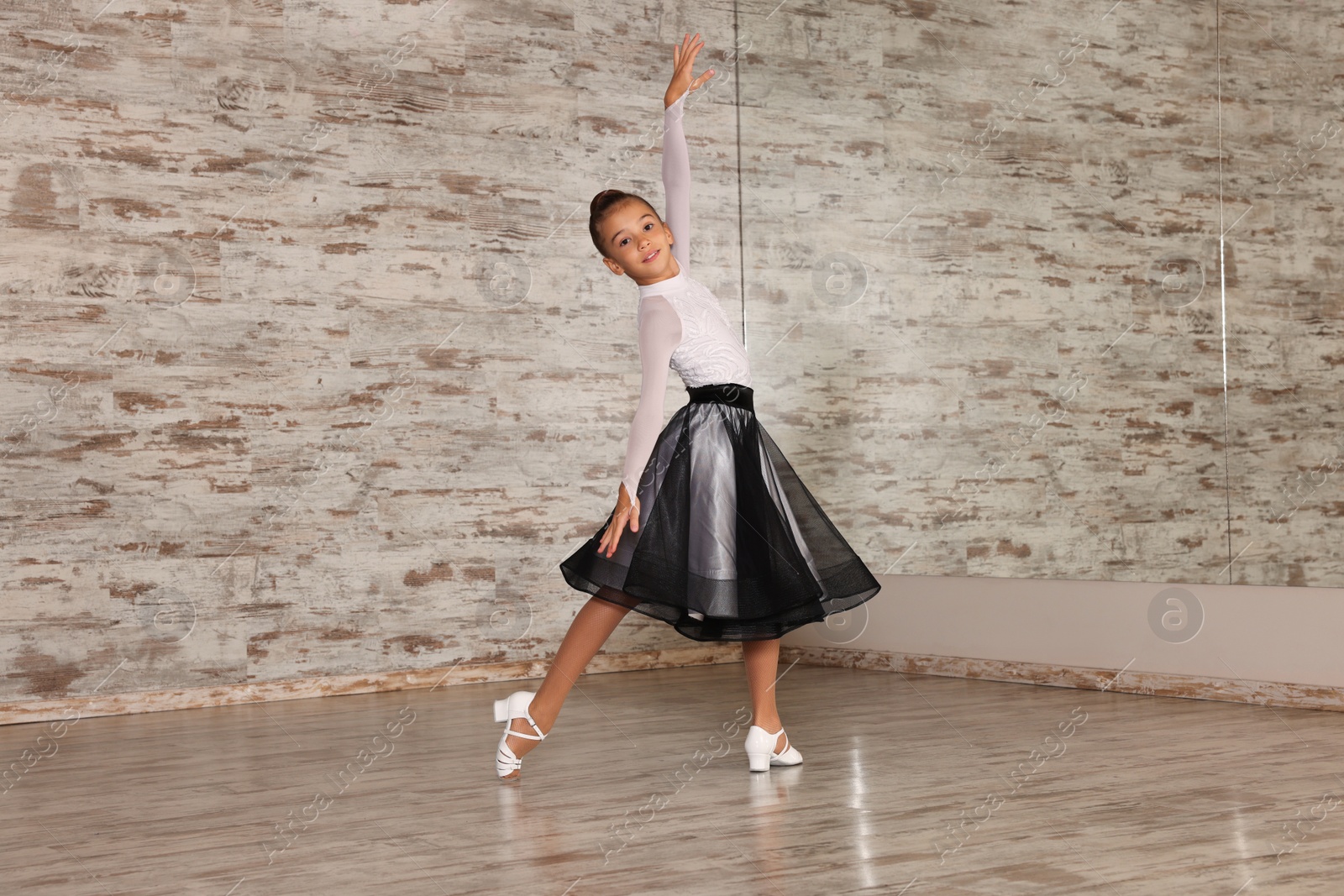 Photo of Beautifully dressed little girl dancing in studio