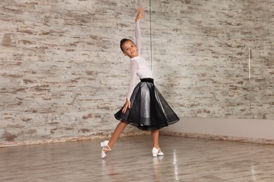 Photo of Beautifully dressed little girl dancing in studio