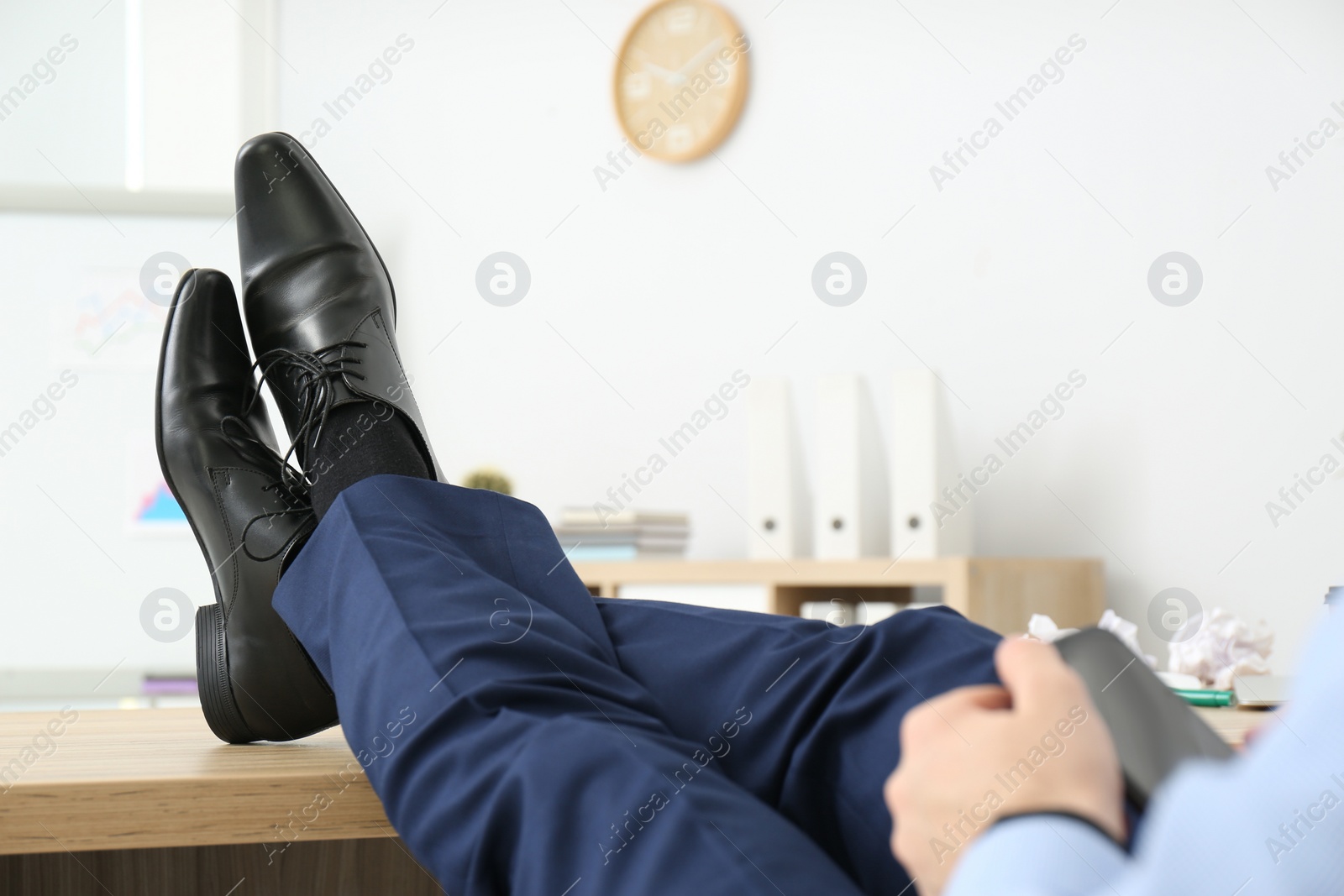Photo of Lazy office employee with mobile phone at workplace, closeup
