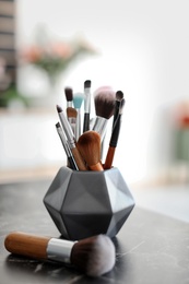 Photo of Holder with makeup brushes on table