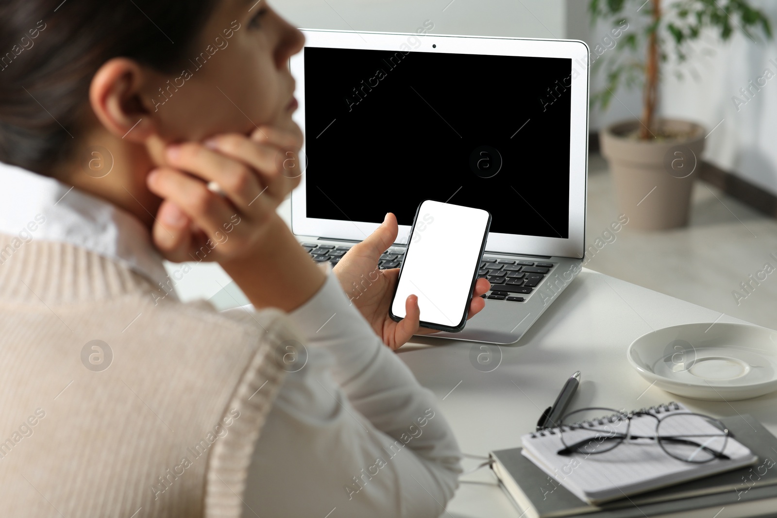 Photo of Woman using smartphone at table in office, closeup