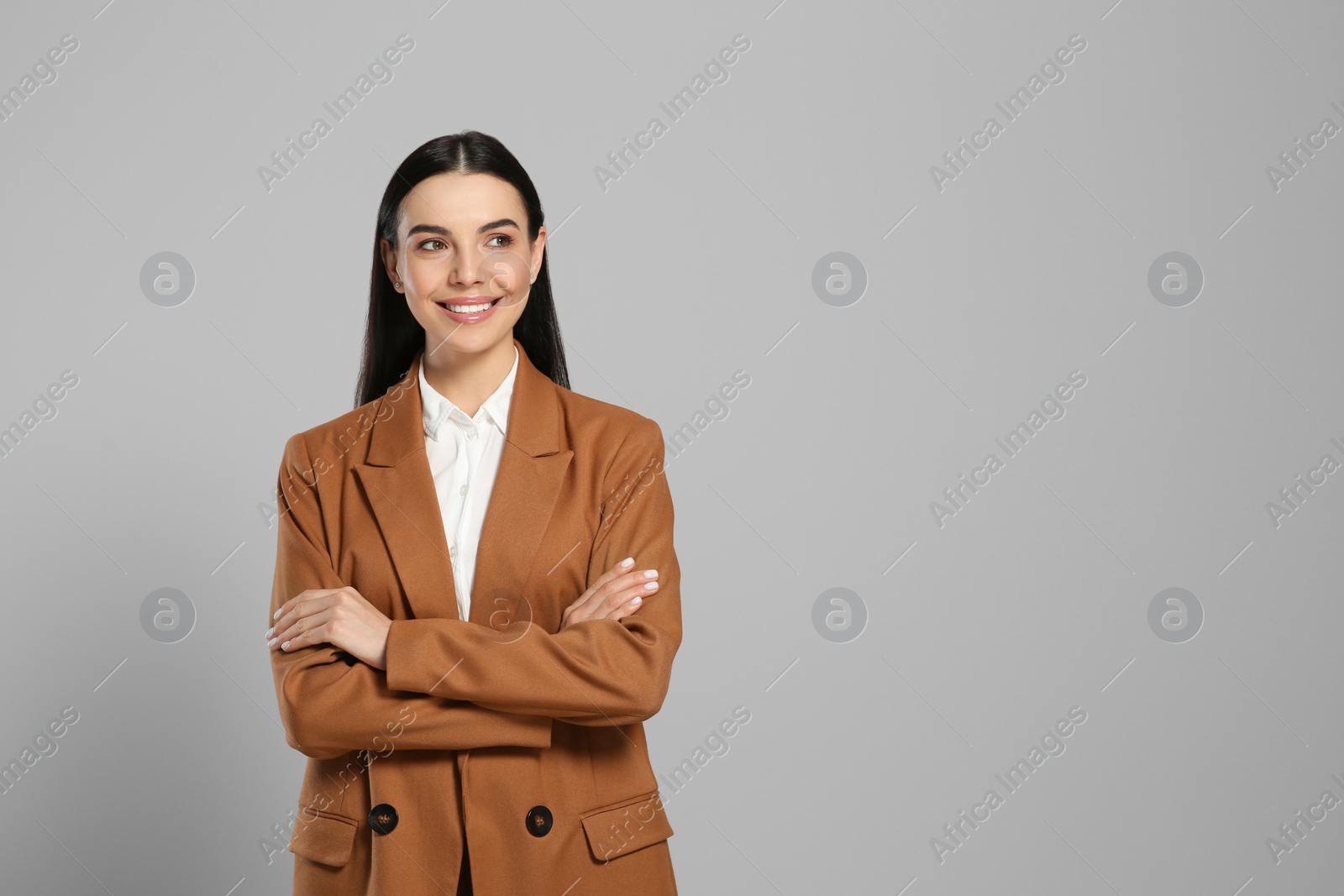 Photo of Beautiful real estate agent in nice suit on grey background, space for text