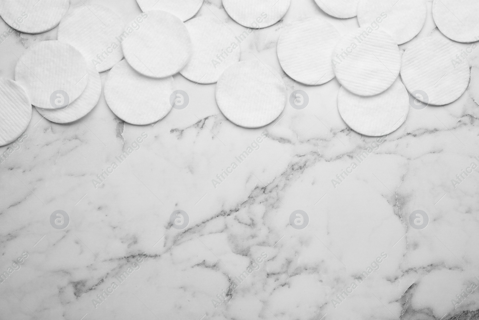 Photo of Many clean cotton pads on white marble table, flat lay. Space for text