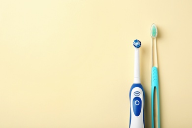 Manual and electric toothbrushes on color background. Dental care