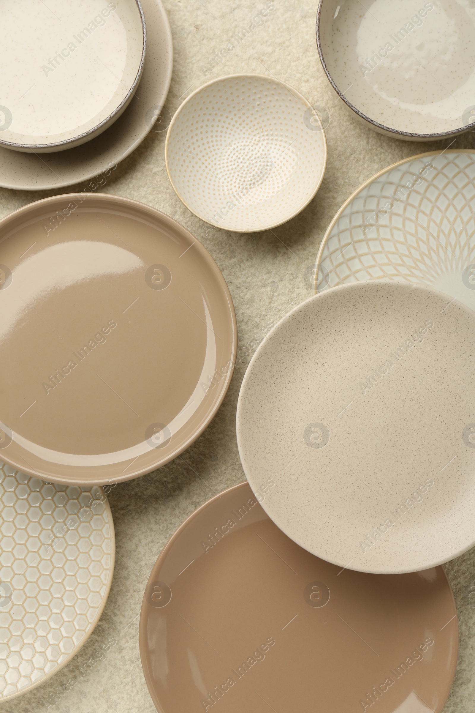 Photo of Beautiful ceramic plates and bowls on beige table, flat lay