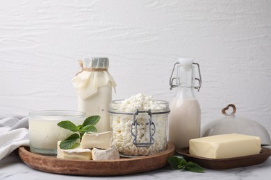 Different dairy products and mint on white marble table