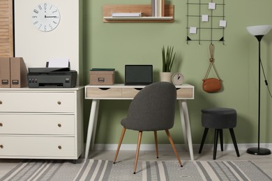 Stylish workplace with laptop and modern printer indoors
