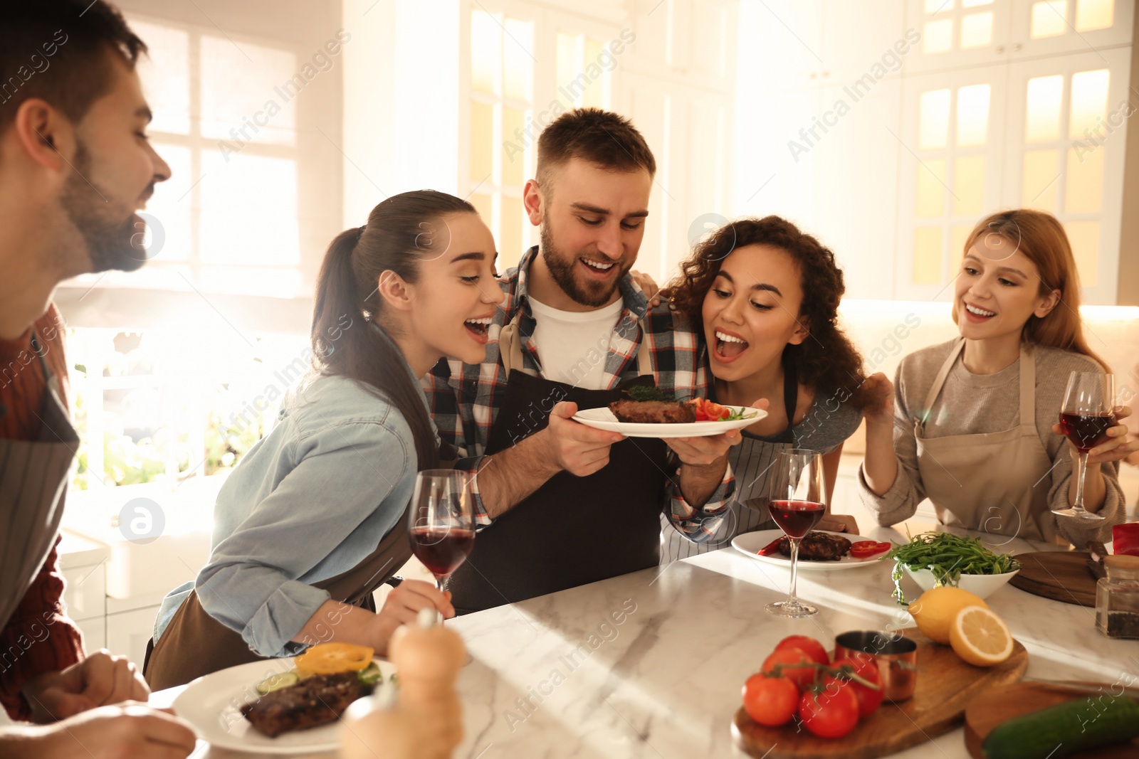 Photo of Happy people with delicious food in kitchen. Cooking class