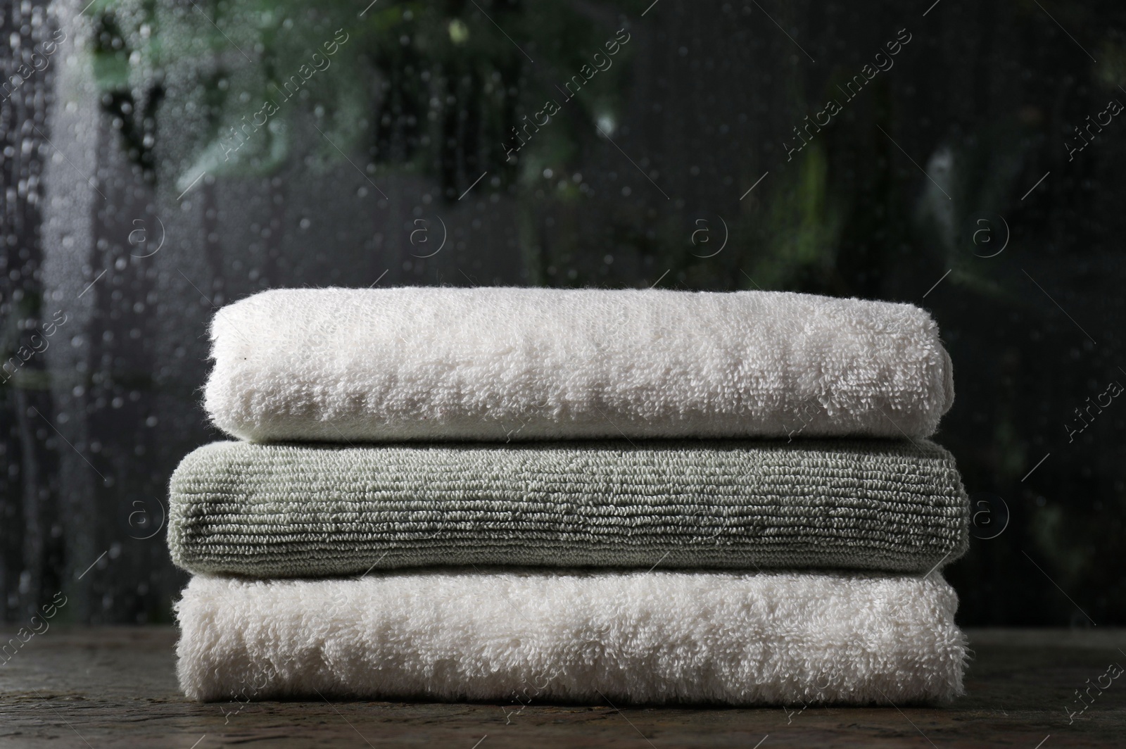 Photo of Stacked terry towels on table in bathroom