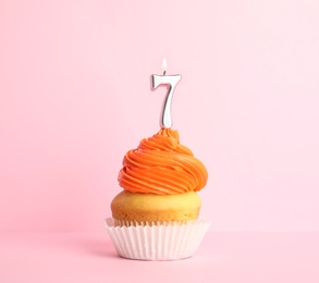 Photo of Birthday cupcake with number seven candle on pink background