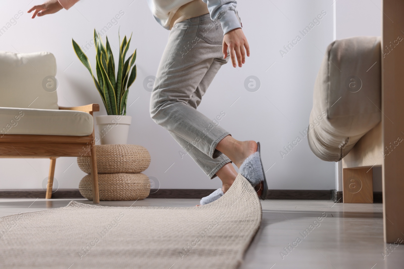 Photo of Woman tripping over carpet at home, closeup