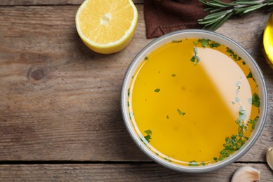 Photo of Bowl of lemon sauce and ingredients on wooden table, flat lay with space for text. Delicious salad dressing