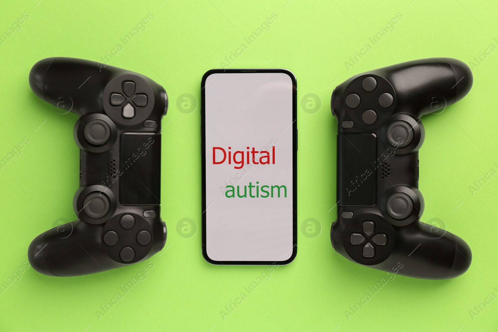 Photo of Smartphone with phrase Digital Autism and gamepads on light green background, flat lay. Addictive behavior