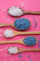 Photo of Spoons with different sea salts on pink background, flat lay