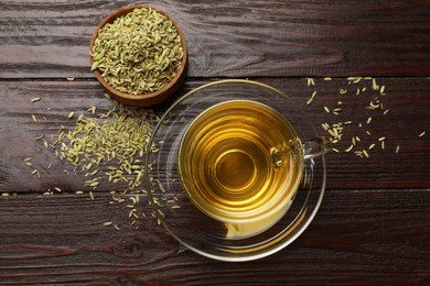 Photo of Aromatic fennel tea and seeds on wooden table, flat lay