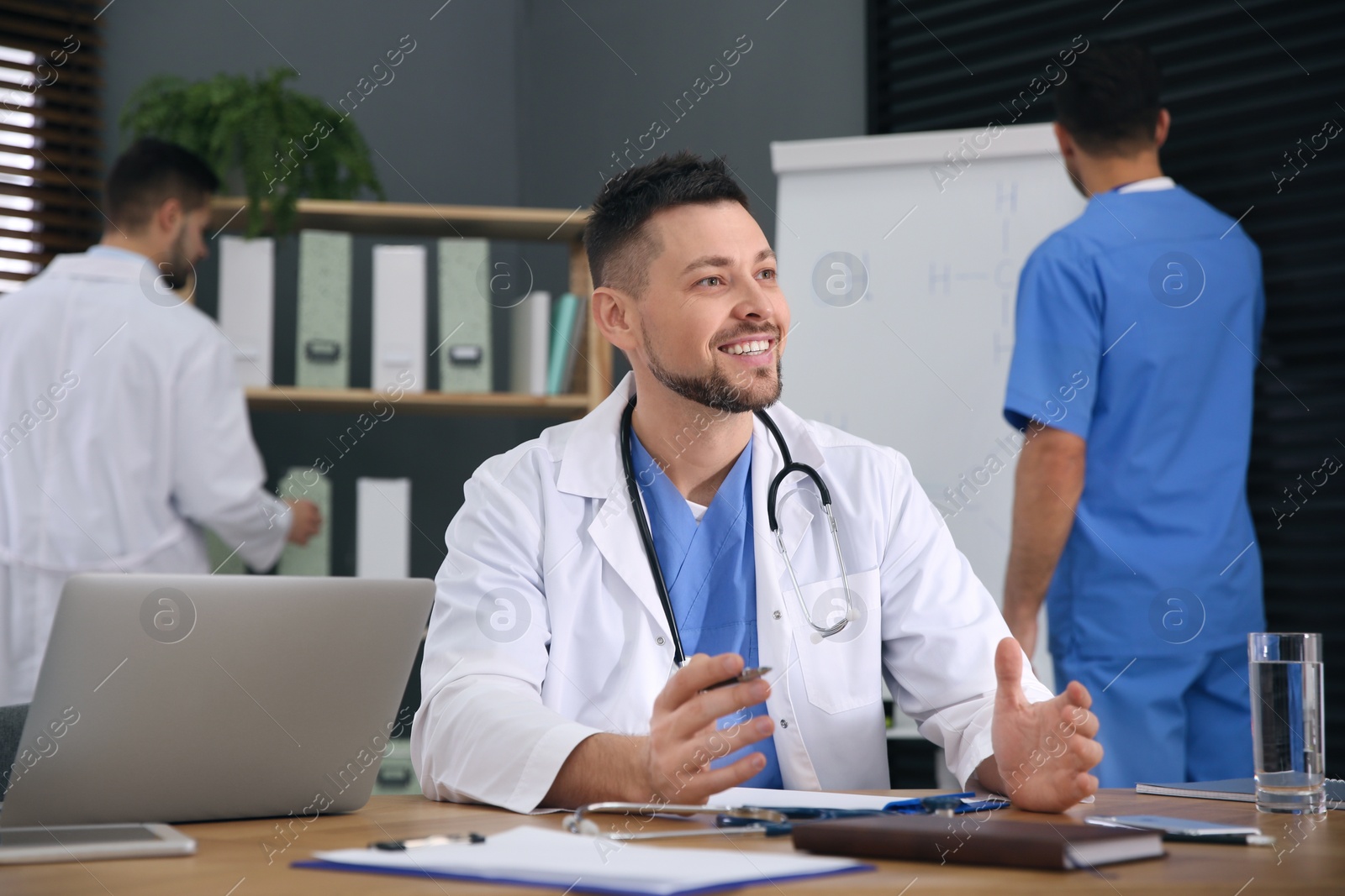 Photo of Team of professional doctors having meeting in office