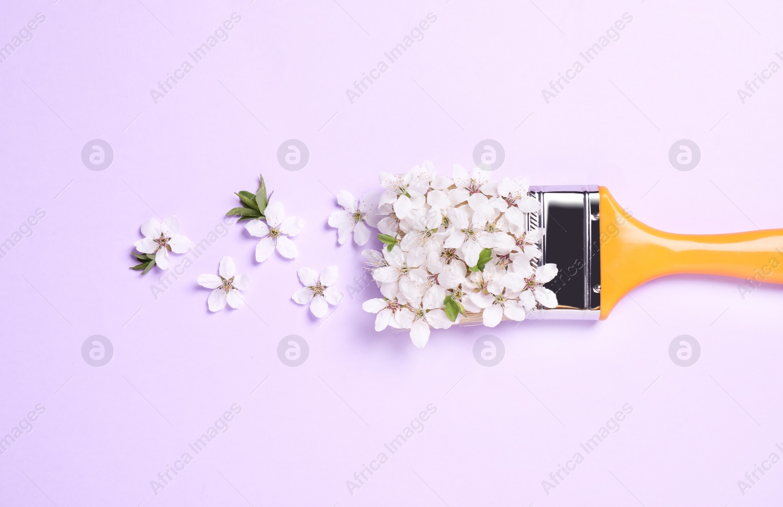 Photo of Paint brush and beautiful flowers on pale violet background, flat lay