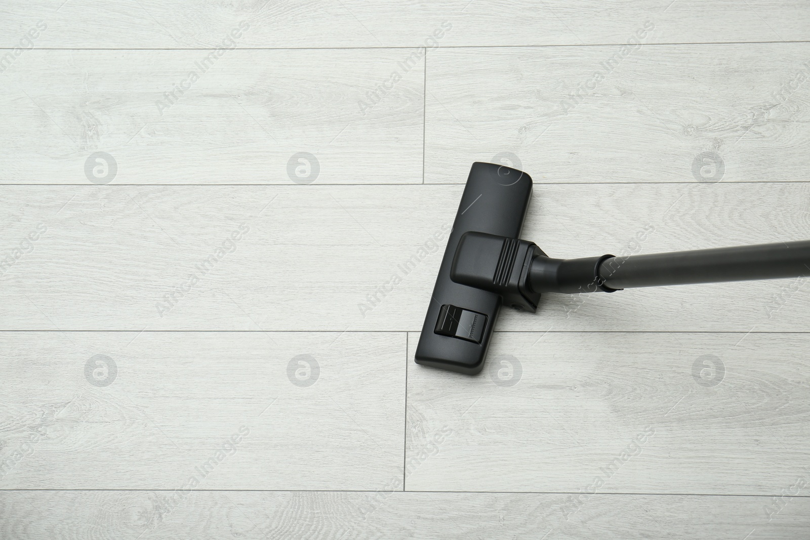 Photo of Hoovering floor with modern vacuum cleaner, top view. Space for text
