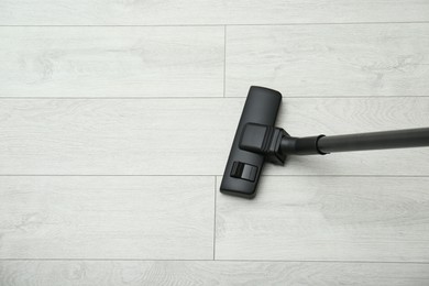 Photo of Hoovering floor with modern vacuum cleaner, top view. Space for text