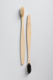 Old bamboo toothbrushes on white background, flat lay