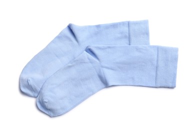 Photo of Pair of light blue socks on white background, top view