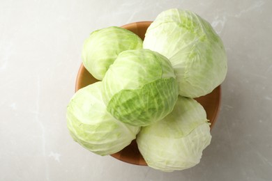 Photo of Ripe white cabbage on light marble table, top view