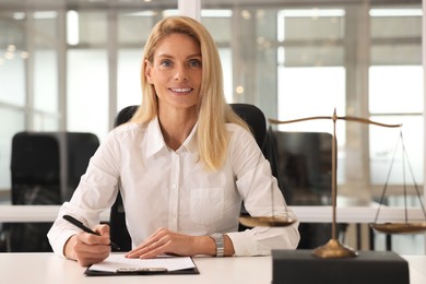 Photo of Portrait of smiling lawyer working at table in office