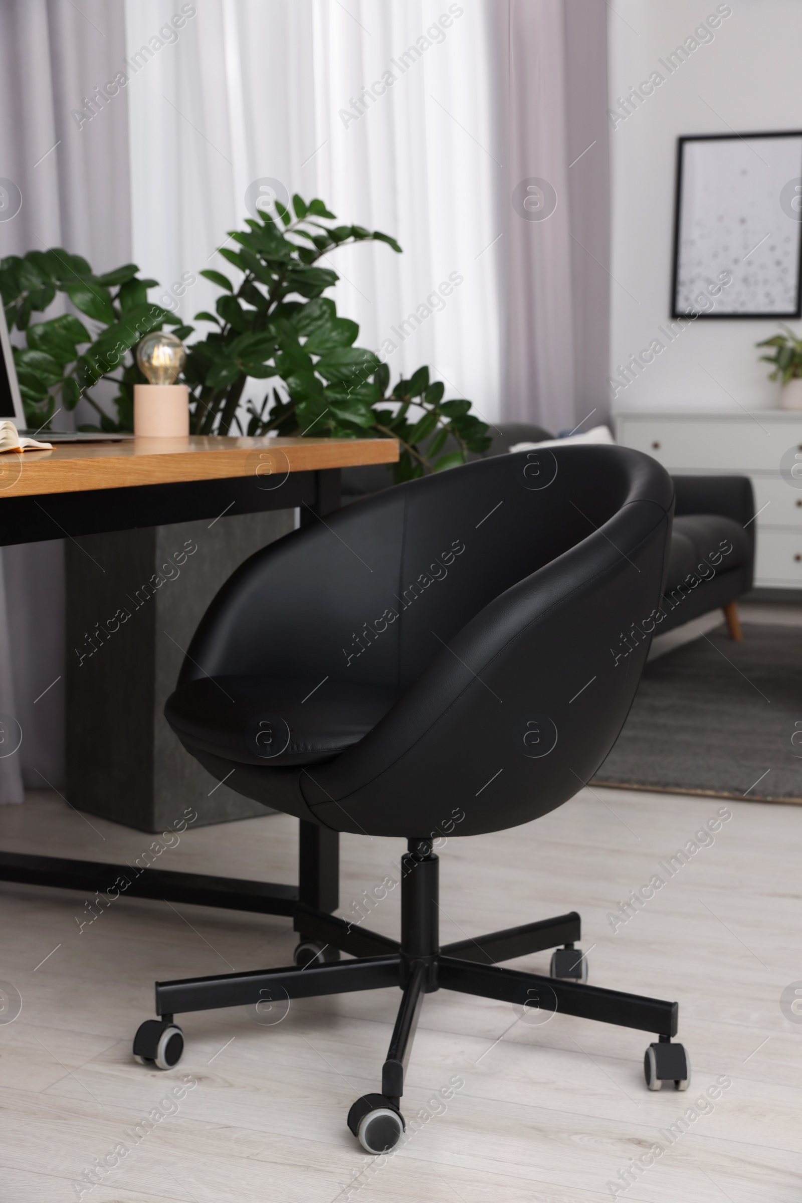 Photo of Comfortable office chair near desk in modern workplace