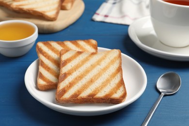 Photo of Slices of tasty toasted bread on blue wooden table