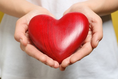 Woman holding red heart, closeup. Donation concept