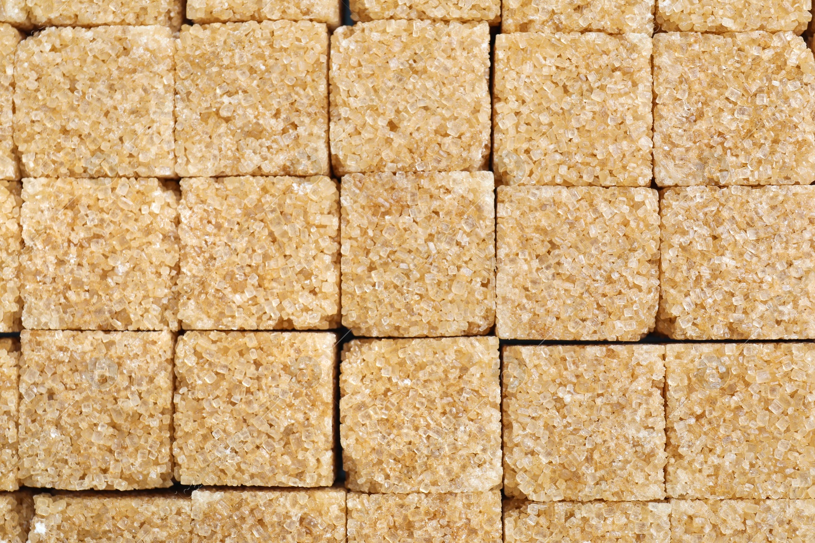 Photo of Brown sugar cubes as background, closeup view