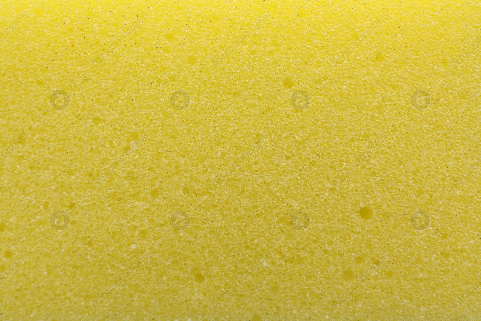 Photo of Yellow cleaning sponge as background, top view
