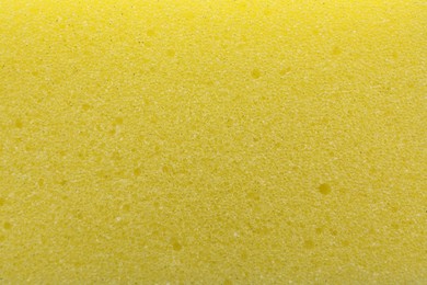 Yellow cleaning sponge as background, top view