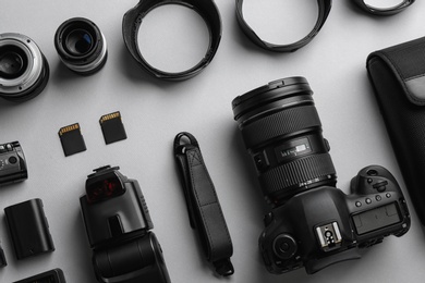 Photo of Flat lay composition with professional photographer equipment on light background