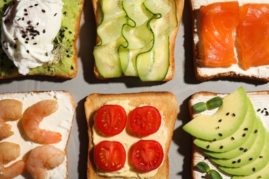 Different delicious toasts on light grey table, flat lay