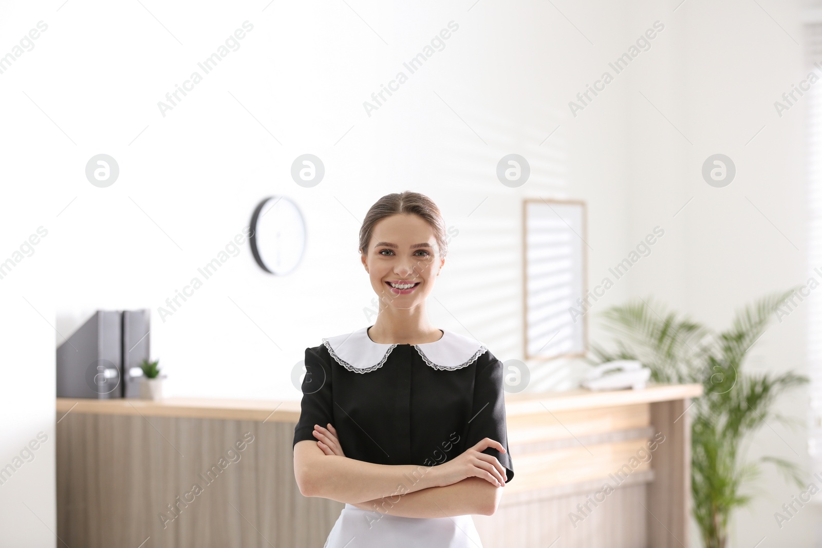 Photo of Portrait of young chambermaid near reception in hotel