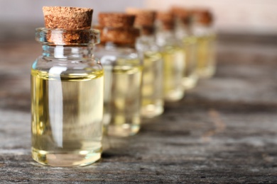 Photo of Glass bottles with essential oil on wooden table