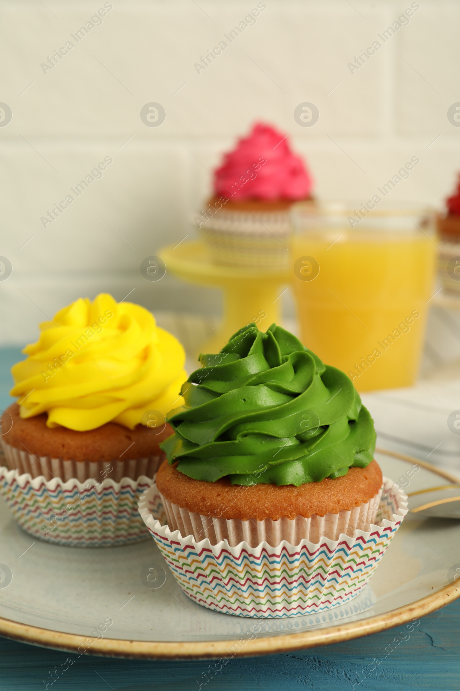 Photo of Delicious cupcakes with colorful cream on table