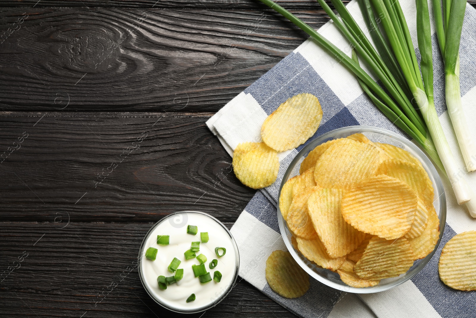 Photo of Flat lay composition with potato chips and sauce on wooden table. Space for text