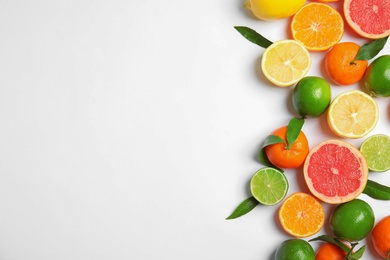 Photo of Different citrus fruits on white background, top view. Space for text