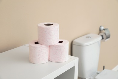 Toilet paper rolls on cabinet in bathroom