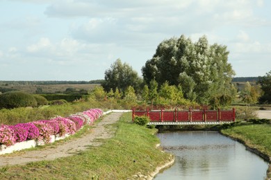 Picturesque view of bridge, river and trees on sunny day