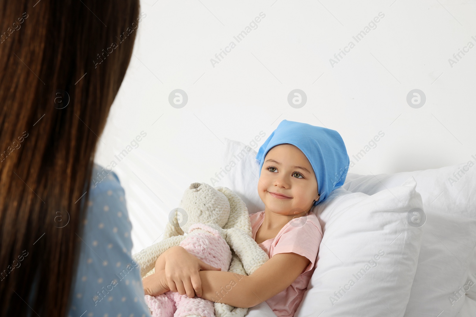 Photo of Childhood cancer. Mother and daughter with toy bunny in hospital