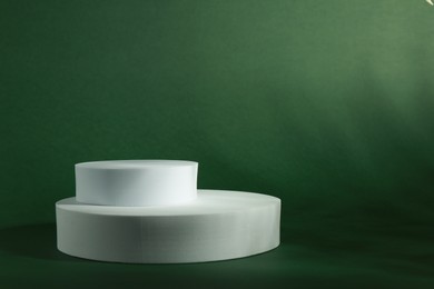 Photo of Product photography props. Round shaped podiums on green background, space for text