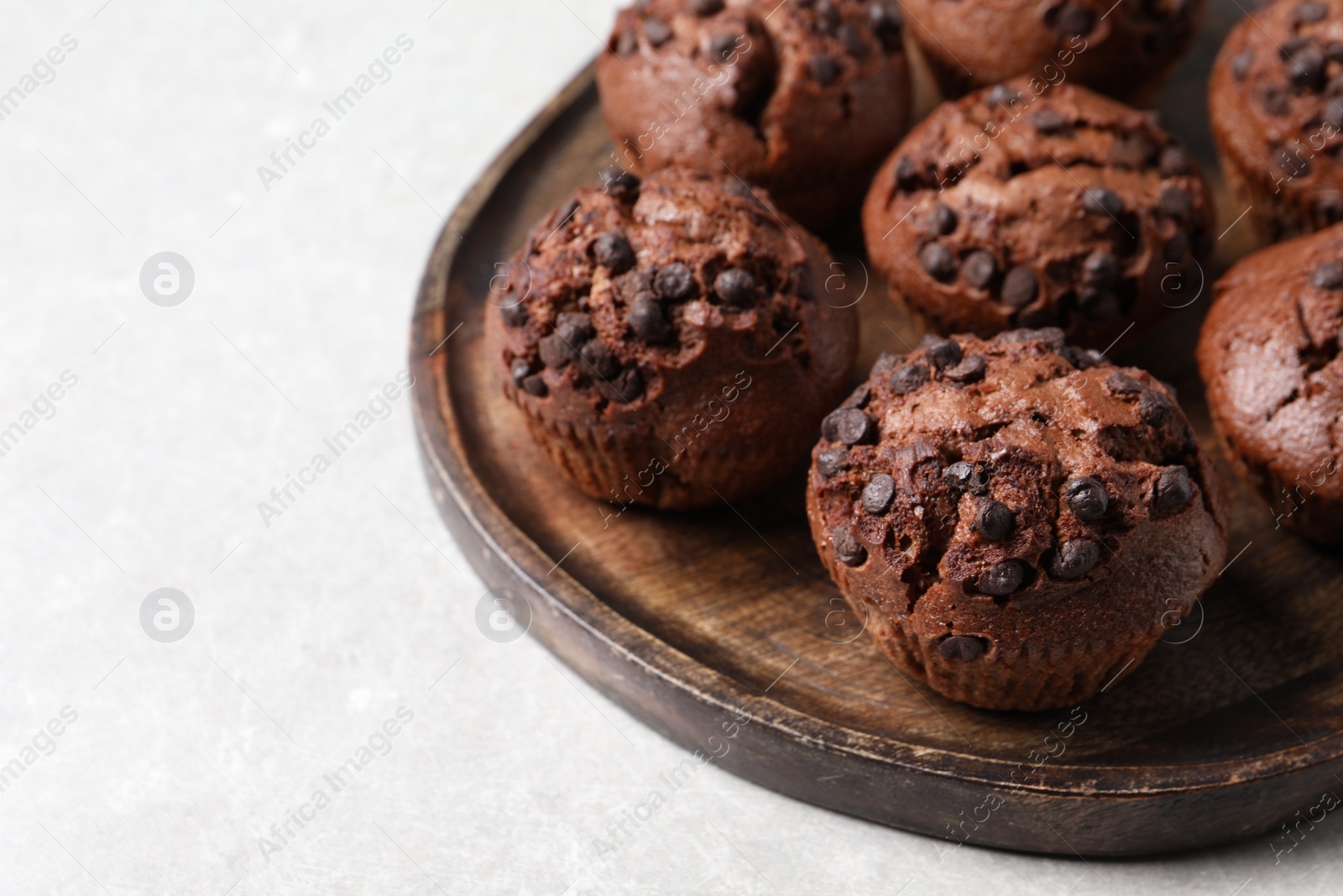 Photo of Tasty chocolate muffins on grey table, closeup. Space for text