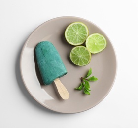 Photo of Plate with delicious spirulina popsicle and lime on white background, top view